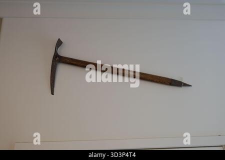 Antique ice axe on white wall Stock Photo