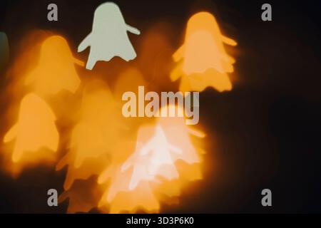 White, yellow, green ghost bokeh on black background - abstract foggy Halloween lights, front view. Stock Photo
