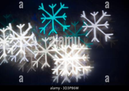 White blue turquoise snowflake bokeh on black background – winter holiday abstract background, front vieww. Stock Photo