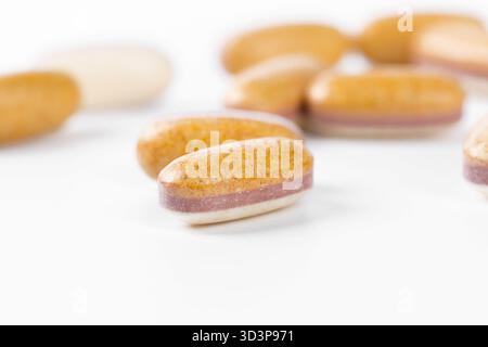 Different types of vitamins and supplements on a clean surface displaying their textures and colors Stock Photo