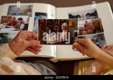 Old woman looking at family photo album Stock Photo - Alamy