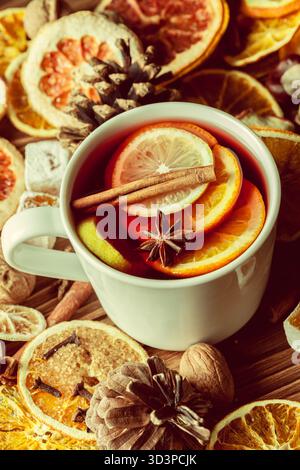 Warm spiced tea with citrus fruits and spices arranged on a wooden surface Stock Photo