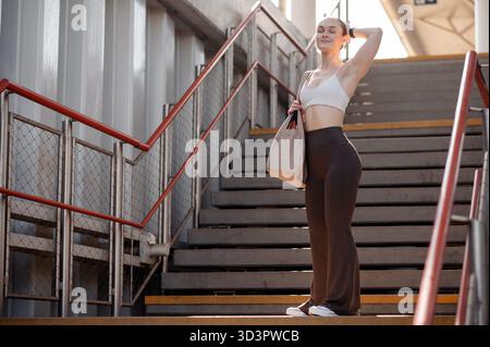 Woman in Activewear on Urban Stairs Stock Photo