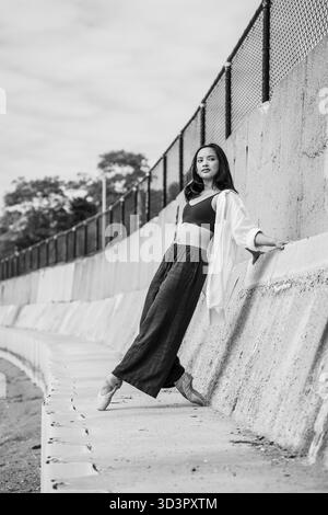 Ballerina on pointe balancing against urban concrete wall Stock Photo