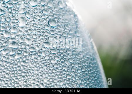 A close-up macro shot capturing numerous water drops on a surface, creating a mesmerizing texture with varying sizes and reflections, showcasing the b Stock Photo