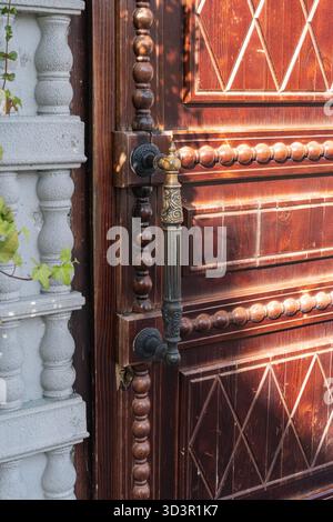 An elegant carved wooden door in Moscow, featuring a decorative metal handle. The intricate detailing and craftsmanship reflect a blend of elegance an Stock Photo