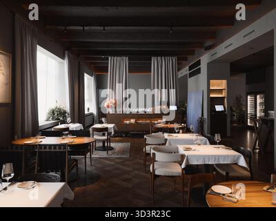 A stylish restaurant interior features wooden tables and soft lighting Stock Photo