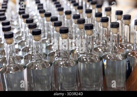 Rows of empty clear glass bottles with cork caps Stock Photo