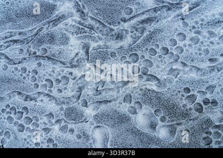 A close-up of intricate frost patterns on a surface, showing beautiful abstract swirls and textures. The icy formations create a visually captivating Stock Photo