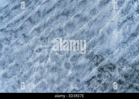 A close-up view of frosty blue ice, showcasing intricate crystalline patterns that create a natural, abstract texture. The cool tones evoke a sense of Stock Photo