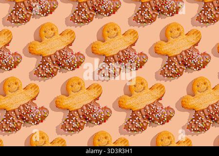 A festive arrangement of gingerbread men cookies, half-dipped in chocolate and adorned with colorful sprinkles, set against a soft beige background, c Stock Photo