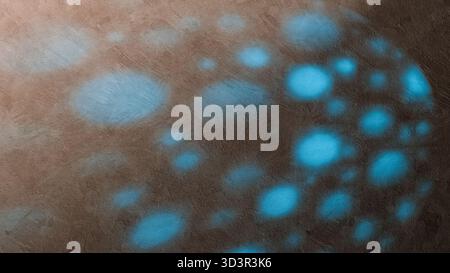 Soft blue shadows dance across a textured wall surface, forming an artistic abstract pattern that captivates the viewer's gaze. Stock Photo