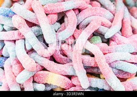 A vibrant mix of colorful gummy worms covered in sugar crystals. Perfect for candy lovers, these treats offer a sweet and tangy delight enjoyed by all Stock Photo