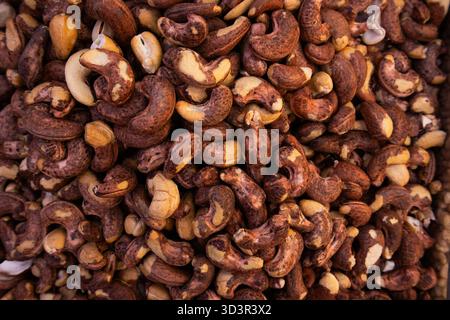 A detailed close-up of numerous raw cashew nuts with their naturally brown texture creating an appealing pattern, perfect for showcasing healthy snack Stock Photo