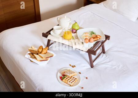 Breakfast spread on a tray served in a cozy hotel room Stock Photo