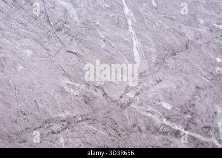 Light gray granite, polished natural stone surface with white and black veins, close-up. Seamless background texture. Stock Photo