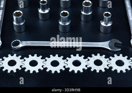 A set of wrenches, hex sockets and gears stacked around the perimeter on a black background. Stock Photo