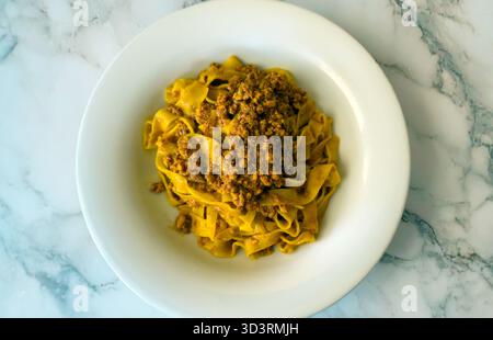 Traditional Italian tagliatelle with bolognese sauce served on white plate Stock Photo