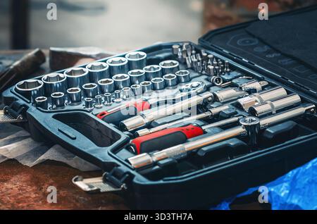 Set of socket wrenches. Professional tool set in black case. Tool set includes socket wrench, ratchet and sockets. Repair of mechanisms background. Stock Photo