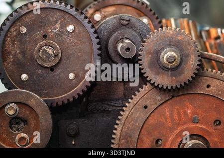 Rusty gear mechanism. Rusty texture, background with mechanical parts, gears, pile of spare parts, old rusty iron wheels, close-up. Stock Photo