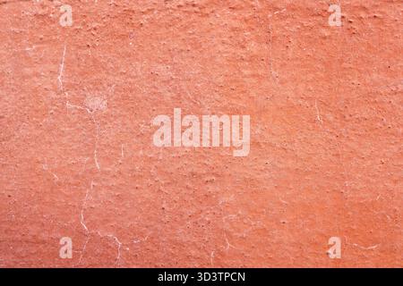 An old broken wall in red, An old concrete wall, A broken wall of plaster a cracked wall, damaged wall paint Stock Photo