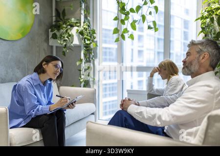 Psycho session. Psychologist having a sessiona with a couple and making notes Stock Photo