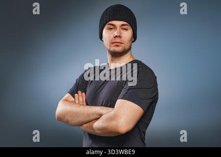 Young strong handsome man posing on gray background Stock Photo