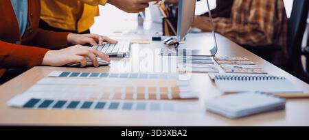 A vibrant workspace shows creative professionals actively collaborating, sharing color samples, and engaging in a productive design process at a Stock Photo