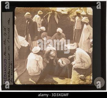 A glass diapositive from circa 1926 showing workers digging up the entrance to a crypt at the Temple of Montu as part of ongoing excavations in Medamud. Stock Photo