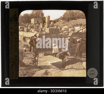 This glass diapositive, taken around 1924-1932, shows workers digging up the third layer of the foundation at the Temple of Montu, part of the excavation process. Stock Photo