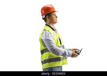 Man in a safety vest holding a drone remote controller isolated on white background Stock Photo