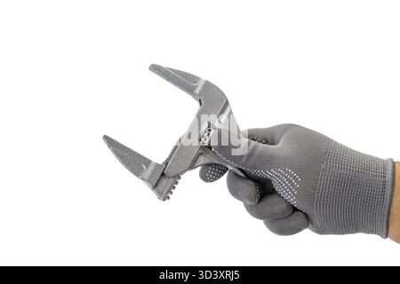 A hand in gray glove holds large width adjustable wrench, showcasing its size and functionality. tool is open wide, emphasizing its capability Stock Photo