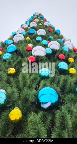 Christmas tree decorated with large multi-colored balls, close-up and view from below Stock Photo