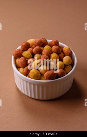 Food, nuts coated with salt and paprika, peanuts as a source of protein. Salted peanuts coated with paprika as a food background for your design Stock Photo
