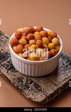 Food, nuts coated with salt and paprika, peanuts as a source of protein. Salted peanuts coated with paprika as a food background for your design Stock Photo