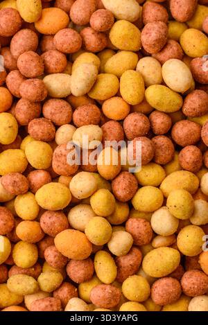 Food, nuts coated with salt and paprika, peanuts as a source of protein. Salted peanuts coated with paprika as a food background for your design Stock Photo