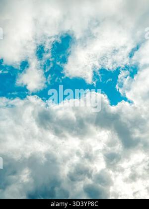 Dramatic cloud formations fill the sky, with vibrant blue patches breaking through the clouds, creating a stunning contrast and an inviting atmosphere Stock Photo