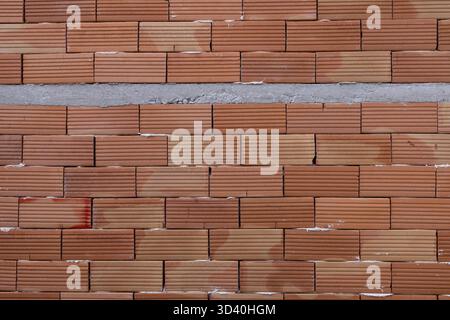 Close-up of Modern Red Clay Bricks Wall with Horizontal Mortar Joint Background Suitable for the Field of Renovations and Construction Stock Photo
