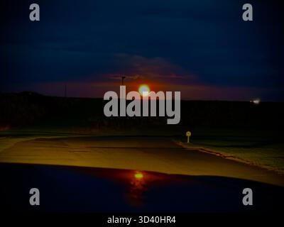 Blood moon over Anglesey, Wales, UK night sky showing vivid red tones during astronomical event. Stock Photo