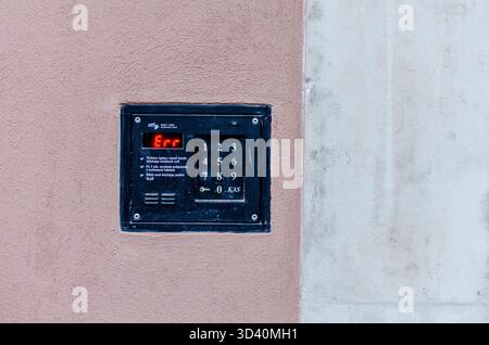 Black building intercom with white buttons and error displayed in red letters on a wall. Stock Photo