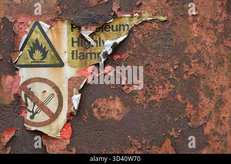 A burnt petroleum highly flammable sign on scorched red metal Stock Photo