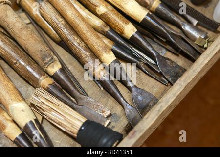 Rustic close up of old woodworking tools. This vintage collection of wooden handled chisel and gouge for carving evokes sense of traditional craft and Stock Photo