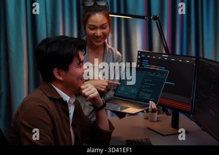 Serious of IT developers discussing intelligent website development coder system running data online two screens with laptop showing information Stock Photo