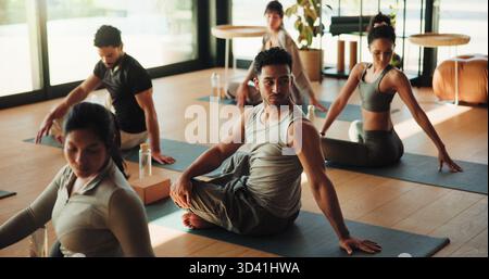 People, fitness and yoga class with coach for spiritual wellness, mindfulness or training. Group, yogi or session with trainer in twice pose for Stock Photo