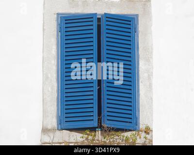 Blue Window Shutters Open Against White Wall, Charming Mediterranean Style Home Décor Stock Photo