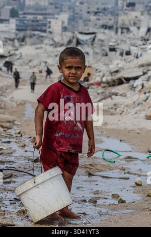 Northern Gaza, Palestine. 04th Nov, 2025. With water networks destroyed and infrastructure collapsed, children now bear the weight of daily survival. They carry heavy water containers across rubble-filled streets, a scene that reflects the harsh conditions and deep suffering civilians endure in the Strip, on November 4, 2025. Photo by Ramez Habboub/ABACAPRESS.COM Credit: Abaca Press/Alamy Live News Stock Photo