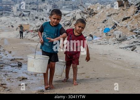 Northern Gaza, Palestine. 04th Nov, 2025. With water networks destroyed and infrastructure collapsed, children now bear the weight of daily survival. They carry heavy water containers across rubble-filled streets, a scene that reflects the harsh conditions and deep suffering civilians endure in the Strip, on November 4, 2025. Photo by Ramez Habboub/ABACAPRESS.COM Credit: Abaca Press/Alamy Live News Stock Photo