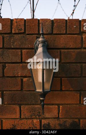 Outdoor lantern mounted on red brick wall Stock Photo