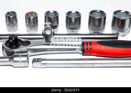 A set of new tools on a white background. Set of adjustable wrenches with handle holder, adapters and extensions and detachable sockets Stock Photo