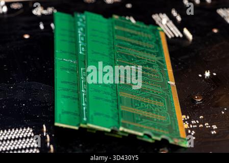 A stack of old SDRAM memory modules lying on a printed circuit board. Stock Photo